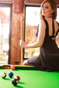 Young woman posing having fun with billiard.