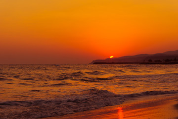 In Rot getränkter menschenleerer Strand bei Sonnenaufgang