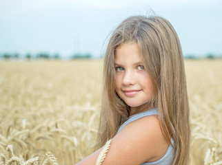 Close-up portrait of a pretty girl with magnetic eyes. Wheat field background