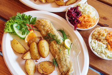 Fish dish - traditional Baltic fried cod fish served with baked potatoes and vegetables.