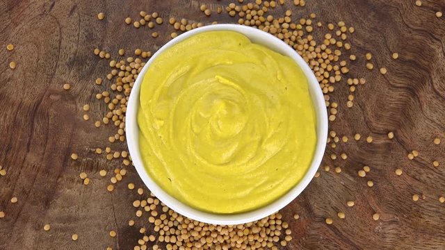 Mustard (rotating on a wooden plate; seamless loopable; 4K)