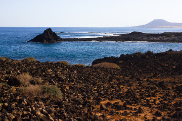 Panoramic ocean view. Volcano, black rocks. Sand macro. Sea background. Horizon.
