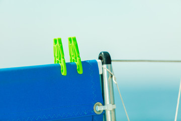 Plastic clothes clips holding blue fabric.