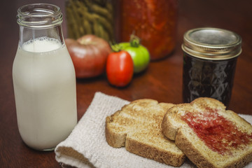 toast and jam with a bottle of milk and vegetables