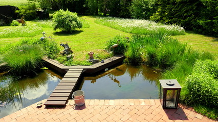 natürlicher Garten und schöner Teich an Terrasse angrenzend