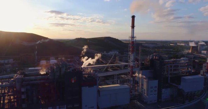 Aerial view Oil refinery with a background of mountains and sky at sunset. Aerial footage.