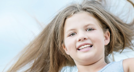 Fototapeta premium Skokowa szczęśliwa urocza mała dziewczynka z długim trzepotliwym włosy