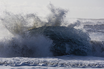 Blocks of ice from the glaciers break up and is washed ashore by the strong waves of the North Atlantic sea in Iceland.