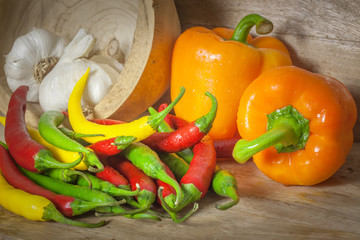 Paprika mit Peperoni und Knoblauch auf Holz