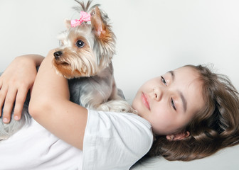 A girl with a dog looking to the side lying on white background