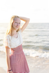 Fototapeta na wymiar hübsches, blondes Mädchen am schönen Strand in der Abendsonne