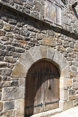 Fototapeta na wymiar La Garde-Guerin, fortified village in Lozere, wooden gate of an old house, in the Cevennes in France 