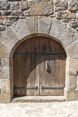 Fototapeta na wymiar La Garde-Guerin, fortified village in Lozere, wooden gate of an old house, in the Cevennes in France 