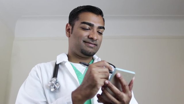 Attractive Doctor Giving Consultation Writing On Prescription Pad 
