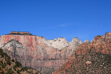 Majestic red, white, and grey mountain range, with green shrubbery, late morning, Zion National Park