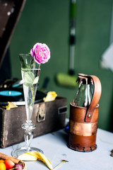 Pink rose in a glass on a background of a gramophone