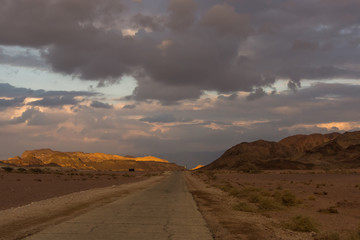 The asphalt road in the red sand dunes in Israel 
