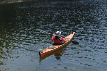 Young woman paddling in alpine lake