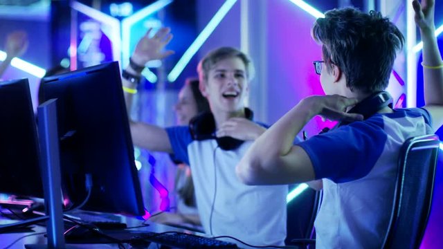 Team of Teenage Gamers Win Internet Cafe Online Video Gaming Tournament and Celebrate with High-Fives. Shot on RED EPIC-W 8K Helium Cinema Camera.