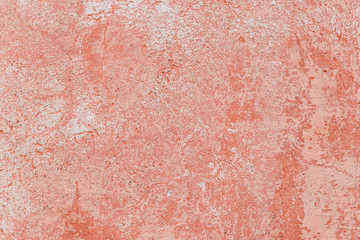 Close-up of a weathered and aged concrete wall with bleached red paint. Texture background.