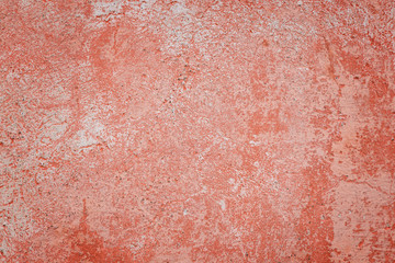 Fototapeta premium Close-up of a weathered and aged concrete wall with bleached red paint. Texture background with vignetting.