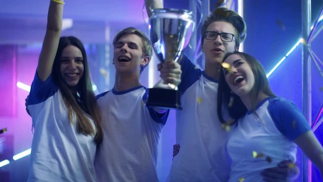 Girls and Boys Winners of Sport/ eSport/ Video Games Tournament Celebrate Their Victory, Lift Trophy. Shot on RED EPIC-W 8K Helium Cinema Camera.
