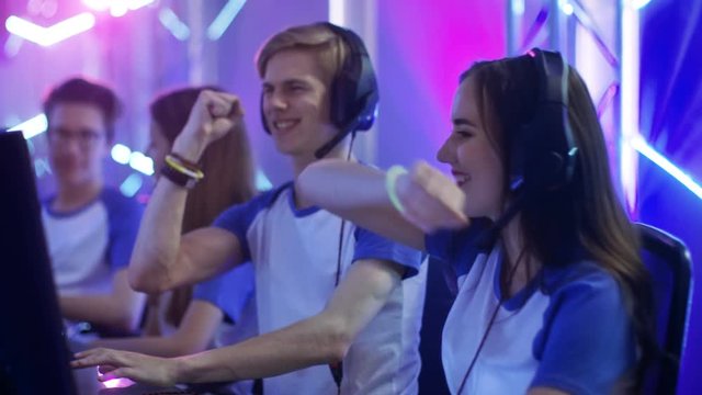 Team of Teenage Gamers Play in Multiplayer  Video Game on a eSport Tournament, High-Fives Each other. Shot on RED EPIC-W 8K Helium Cinema Camera.