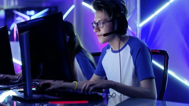Team of Teenage Gamers Play in Multiplayer  Video Game on a eSport Tournament. Captain Gives Commands into Microphone, Trying Strategically Win the Game. Shot on RED EPIC-W 8K Helium Cinema Camera.