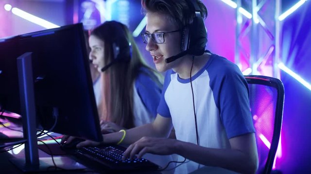 Team of Teenage Gamers Play in Multiplayer PC Video Game on a eSport Tournament. Emotional Game Moment. Shot on RED EPIC-W 8K Helium Cinema Camera.