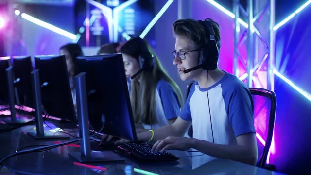 Team of Teenage Gamers Play in Multiplayer PC Video Game on a eSport Tournament. Captain Gives Commands into Microphone, Trying Strategically Win the Game. Shot on RED EPIC-W 8K Helium Cinema Camera.