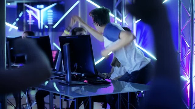 Team of Professional eSport Gamers Playing in Competitive Video Games on a Cyber Games Tournament. Team Wins, Spectators Applaud. Shot on RED EPIC-W 8K Helium Cinema Camera.