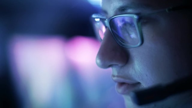 Close-up of Teenager Wearing Glasses Playing Video Games in His Headset Giving Commands into Microphone. Shot on RED EPIC-W 8K Helium Cinema Camera.