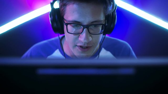 Professional Gamer Plays in MMORPG/ Strategy/ Shooter Video Game on His Computer. He's Participating in Online Cyber Games Tournament, Plays at Home, or in Internet Cafe. 