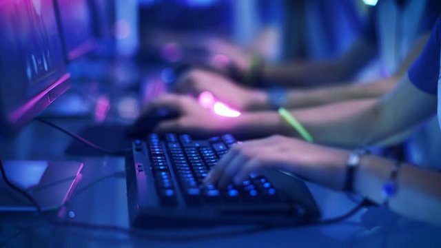  Close-up On Row of Gamer's Hands on a KeyBoard.jpgs, Actively Pushing Buttons, Playing MMO Games Online. Background is Lit with Neon Lights.Shot on RED EPIC-W 8K Helium Cinema Camera.