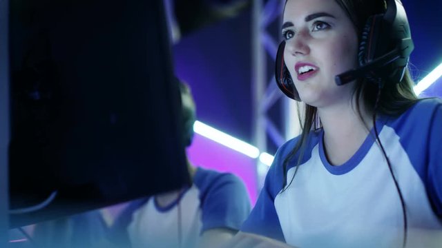 Beautiful Professional Gamer Girl and Her Team Participate in eSport Cyber Games Tournament. She Has Her Headphones and Talks into Microphone. Shot on RED EPIC-W 8K Helium Cinema Camera.