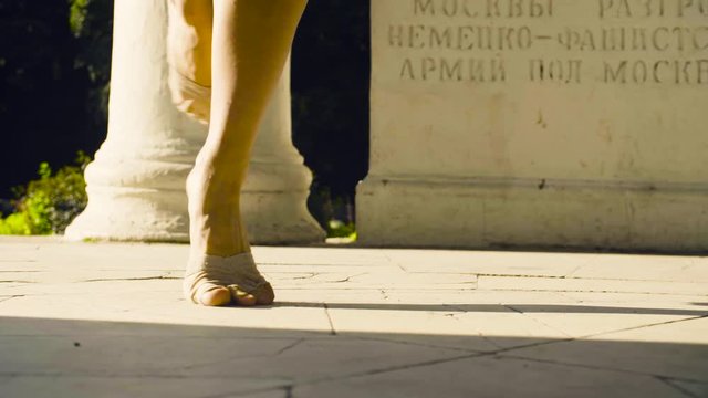 Bare feet of a woman dancing on a stone floor
