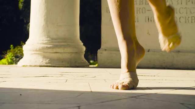 Bare feet of a woman dancing on a stone floor