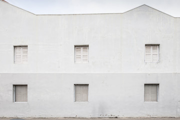 White cement wall with old windows in chaintown, Singapore