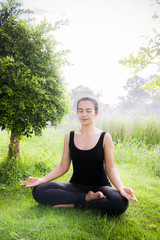 Young woman practicing yoga Everyday Yoga helps in concentration, meditation,breath, shape, strength, help skin brighten. Among the Dharma Air in bright days