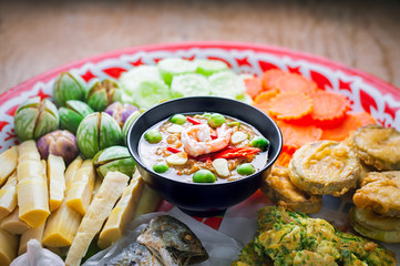 Shrimp - paste sauce with vegetables, omelet, fried mackerel  on wooden table.