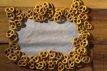 the frame of pretzel on peper on wooden background