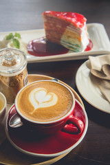 red cup coffee time and tasty cake on wood table in cafe restaurant.