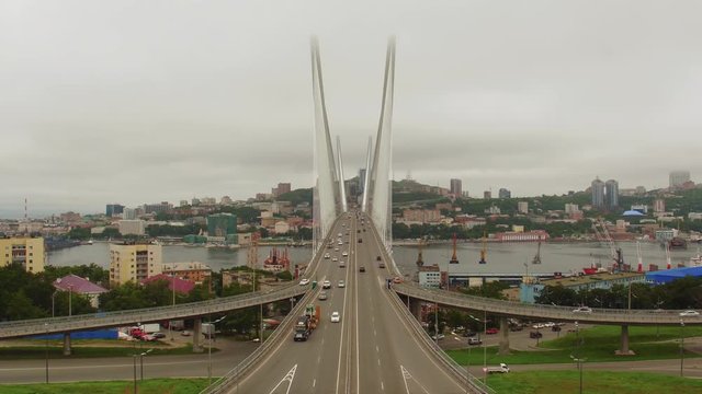 Amazing zooming out aerial view of the Zolotoy Bridge (the Golden Bridge) that is cable-stayed bridge across the Zolotoy Rog built in 2012 in Vladivostok, Russia, and cars driving on it. 4k
