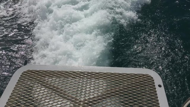 The white wash of the wake of a cruising boat on the water.