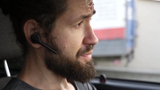 Man driving a car at countryside and using hands free device to make a call