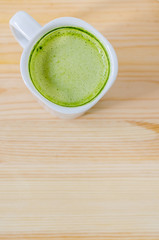 Milk green tea on wooden table
