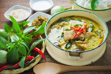 Thai food green curry chicken on wooden background.