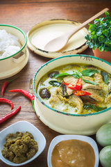 Thai food green curry chicken on wooden background.