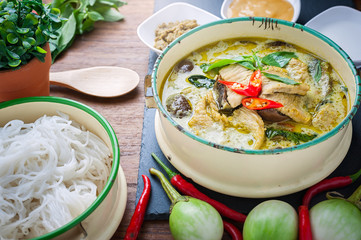Thai food green curry chicken on wooden background.