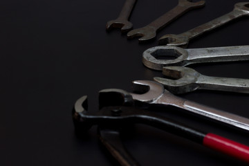 Wire cutters, pliers and wrench. Low key Tools on darkness background.